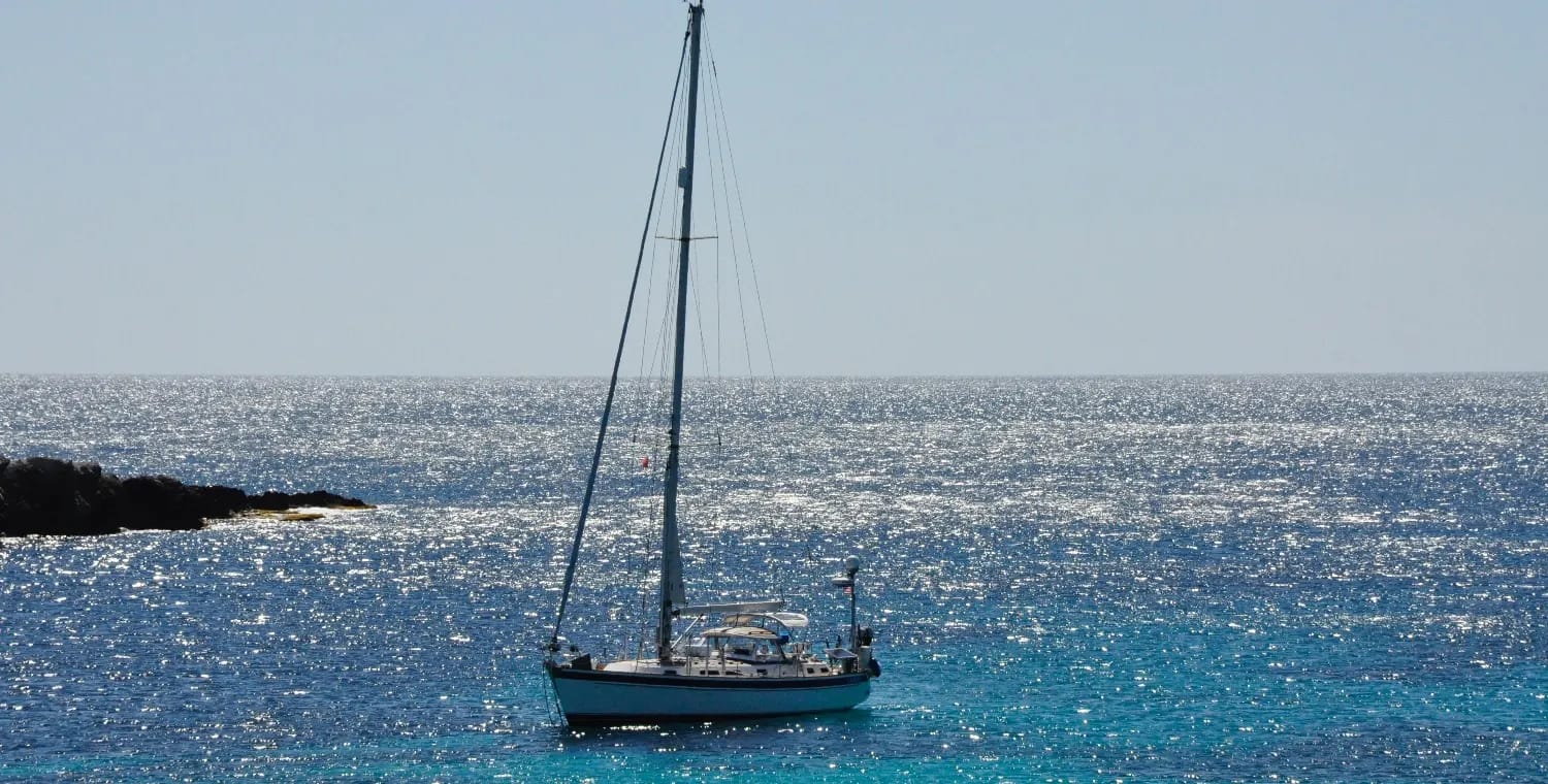 Cadence, a 43 foot Hallberg-Rassy, at anchor over turquoise water